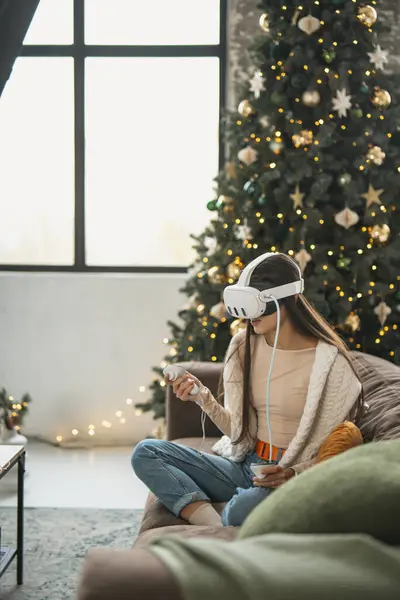 一个时髦的年轻女人在一个虚拟现实的耳机里享受着家里的节日气氛 高质量的照片 — 图库照片