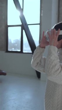 Göz kamaştırıcı genç bir kadın sanal gerçeklik gözlükleriyle bir Noel ağacını izliyor. Yüksek kalite 4k görüntü