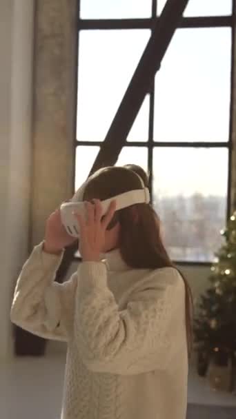 Μια Όμορφη Νεαρή Κοπέλα Εξετάζει Ένα Χριστουγεννιάτικο Δέντρο Φορώντας Γυαλιά — Αρχείο Βίντεο