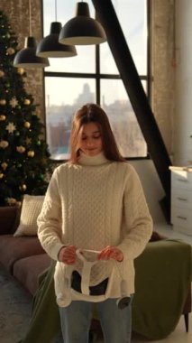 Şık bir genç kadın sanal gerçeklik gözlüğü takarak bir Noel ağacını inceliyor. Yüksek kalite 4k görüntü