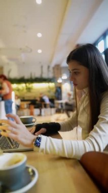 Tıp fakültesinden genç bir öğrenci bir kafede bilgisayar ve telefon kullanarak internetten okuyor. Yüksek kalite 4k görüntü