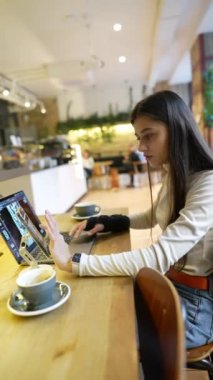Tıp fakültesinden bir öğrenci internette bir kafede okuyor, bir telefon ve bir dizüstü bilgisayar kullanıyor. Yüksek kalite 4k görüntü