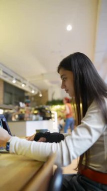 Güzel görünen genç bir öğrenci bir kafede dizüstü bilgisayar kullanıyor. Yüksek kalite 4k görüntü