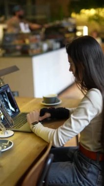 Bir kafede dizüstü bilgisayarı ve kahvesi olan çekici genç bir tıp öğrencisi. Yüksek kalite 4k görüntü