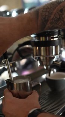 Barista, yiyecek dükkanında kahve yaparken süt döker. Yüksek kalite 4k görüntü