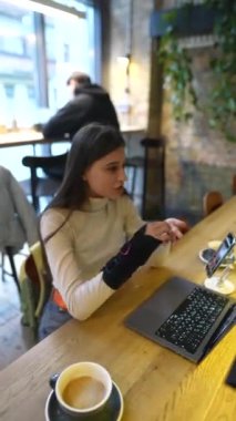 Tıp fakültesinden çekici bir öğrenci bir kafede dizüstü bilgisayar kullanarak konferansa katılıyor. Yüksek kalite 4k görüntü