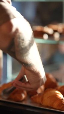 Satıcı müşteri için kruvasanları kese kağıdına koyuyor. Yüksek kalite 4k görüntü