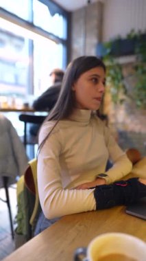 Bir kafe ortamında, tıp fakültesinden sevimli bir öğrenci dizüstü bilgisayarla bir ders dinliyor. Yüksek kalite 4k görüntü