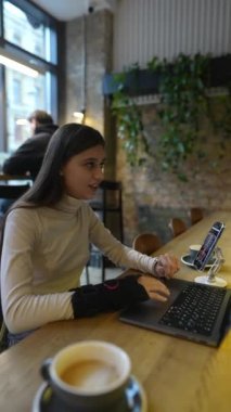 Bir kafede, tıp okuyan bir öğrenci bir dizüstü bilgisayarın yardımıyla çevrimiçi öğrenme ile meşgul olur. Yüksek kalite 4k görüntü