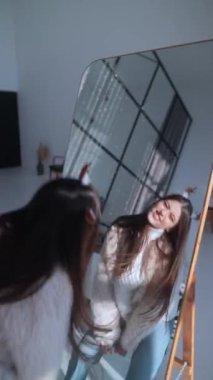 Noel geyiği maskesi takan genç bir bayan aynanın önünde dans ediyor. Yüksek kalite 4k görüntü