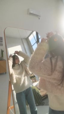 Noel geyiği maskesi takan zeki genç bir bayan aynanın önündeki yansımasına hayran. Yüksek kalite 4k görüntü