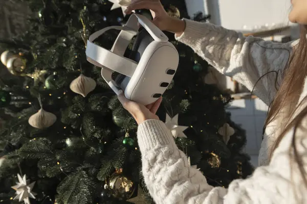 Een Kerstboom Vormt Achtergrond Als Een Meisje Houdt Een Virtual Rechtenvrije Stockfoto's
