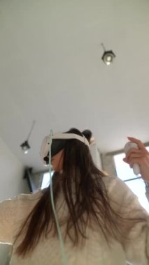 Dinamik bir online oyuna kendini kaptırmış zeki bir genç kız sanal gerçeklik kulaklığı takıyor. Yüksek kalite 4k görüntü