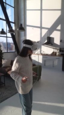 Üç boyutlu sanal gerçeklik gözlükleriyle, sevimli genç bir bayan evde sanal bir oyun oynuyor. Yüksek kalite 4k görüntü