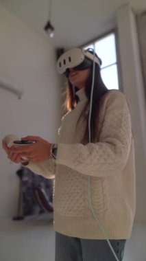 Sanal gerçeklik kulaklığı kullanan genç bir kadın çevrimiçi bir sanal oyuna daldı. Yüksek kalite 4k görüntü