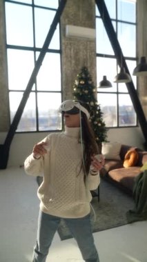 Canlı bir online oyun oynayan dinamik genç bir bayan sanal gerçeklik kulaklığı kullanıyor. Yüksek kalite 4k görüntü