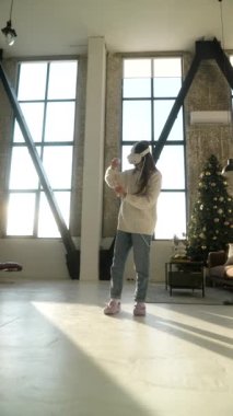 İnternette aktif oyun oynayan dinamik genç bir kadın sanal gerçeklik kulaklığını kullanıyor. Yüksek kalite 4k görüntü