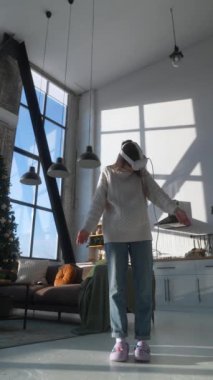 Arka planda bir Noel ağacı ile, güzel genç bir kadın içeride bir VR kulaklığı kullanıyor. Yüksek kalite 4k görüntü