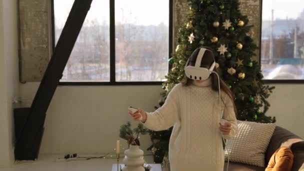 一个穿着虚拟现实装置的年轻漂亮的女人站在圣诞树的后面 高质量的4K镜头 — 图库视频影像