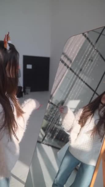 一个年轻迷人的女孩戴着圣诞驯鹿面具在镜子前跳舞 高质量的4K镜头 — 图库视频影像