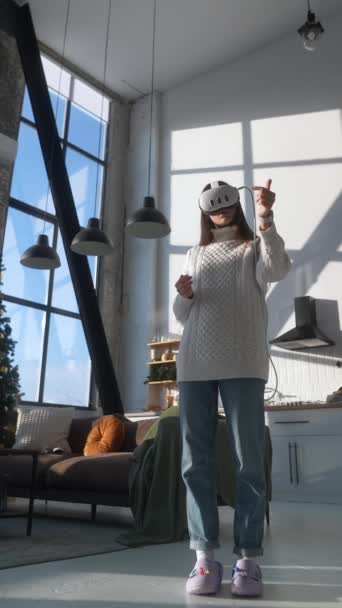 在圣诞树前 一位可爱的年轻女士在她的公寓里使用一个虚拟现实耳机 高质量的4K镜头 — 图库视频影像