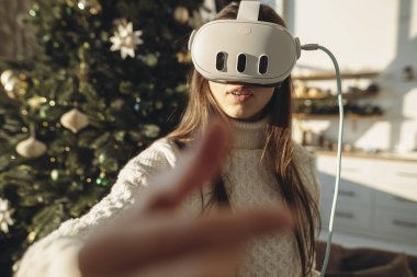 VR kulaklıklı güzel bir kızı Noel ağacının şenlikli zemininde gösteren bir portre. Yüksek kalite fotoğraf