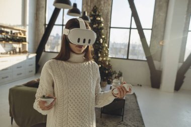 Sanal gerçeklik kulaklığı takan sevimli genç bir bayan izlenimlerinden bahsediyor. Yüksek kalite fotoğraf