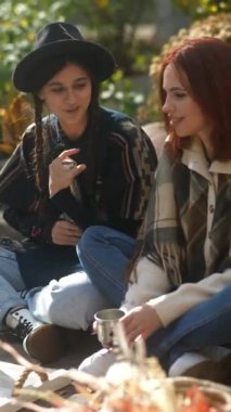 Hippi havasını kucaklayan güzel genç kadınlar, sonbahar parkındaki bir karavanın yanında neşe içinde vakit geçiriyorlar. Yüksek kalite 4k görüntü