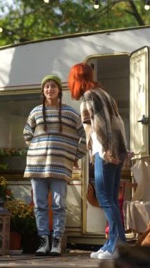 Şık hippi kıyafetleriyle, modern genç bayanlar bir sonbahar kampında karavanıyla vakit geçirmekten zevk alıyorlar. Yüksek kalite 4k görüntü