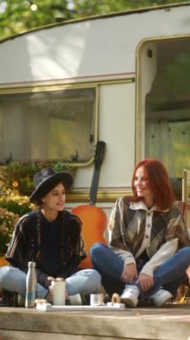 İki güzel genç kız bir karavanın yanında eğlenirken hippi kıyafetinin neşeli ruhu açıkça görülüyor. Yüksek kalite 4k görüntü