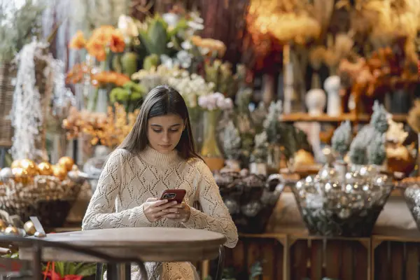 A beautiful woman explores the decor store with her phone in hand. High quality photo