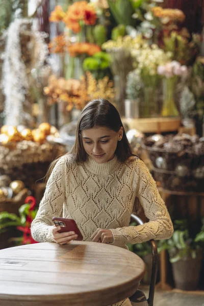 Een Mooie Jonge Vrouw Houdt Haar Telefoon Vast Terwijl Door Rechtenvrije Stockfoto's