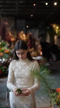 Kurnaz bir Noel çelengi yapan güzel bir genç kadının resimli bir sahnesi. Yüksek kalite 4k görüntü