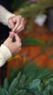 Evergreen dalları yetenekli bir zanaatkarın ellerinde şenlikli bir dönüşüme uğrar. Yüksek kalite 4k görüntü