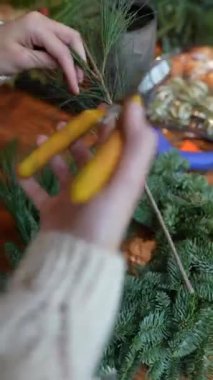 Evde genç ve güzel bir kadın tarafından cazibeyle teslim edilmiş bir Noel çelengi yapma rehberliği. Yüksek kalite 4k görüntü