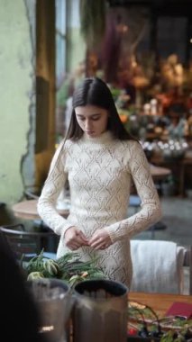 Bir usta sınıfında Noel çelengi hazırlama sürecini anlatan detaylı bir fotoğraf seansı. Yüksek kalite 4k görüntü