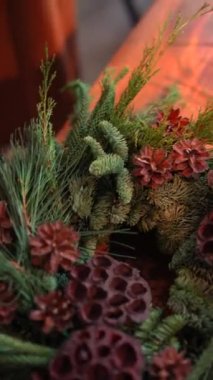 Ayrıntılı bir zanaat atölyesi sırasında Noel çelengi yapma sürecini gösteren kapsamlı görseller. Yüksek kalite 4k görüntü