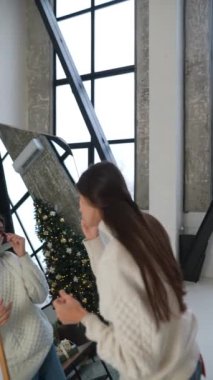 Modayı takip eden genç bir bayan saçını şekillendirerek Noel partisine hazırlanıyor. Yüksek kalite 4k görüntü