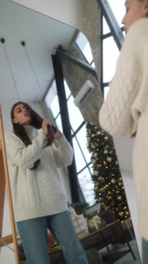 Şık ve göz kamaştırıcı bir bayan Noel ağacının ışıltısıyla çevrili olan parti için hazırlanıyor. Yüksek kalite 4k görüntü