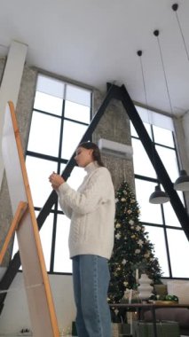 Bir Noel partisine hazırlanan şık bir kız saçlarını zarif bir şekilde şekillendirir. Yüksek kalite 4k görüntü