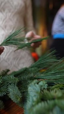Genç ve çekici bir kadın tarafından sunulan evinizde Noel çelengi yaratma üzerine bir ders. Yüksek kalite 4k görüntü