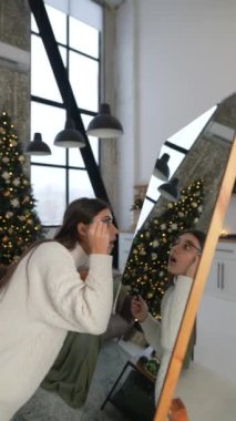 Noel havası yaratmak için güzel bir kız aynanın karşısına makyaj yapar. Yüksek kalite 4k görüntü