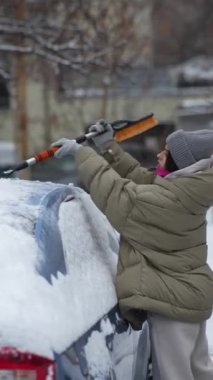 Arabasındaki karın sorumluluğunu üstlenen genç bir kadın park yerinde. Yüksek kalite 4k görüntü
