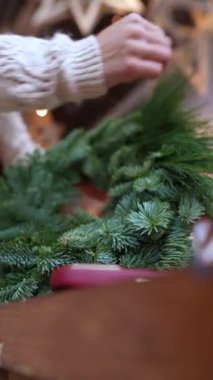 Çiçekçi tezgahında sergilenen Noel çelenginin son rötuşları. Yüksek kalite 4k görüntü