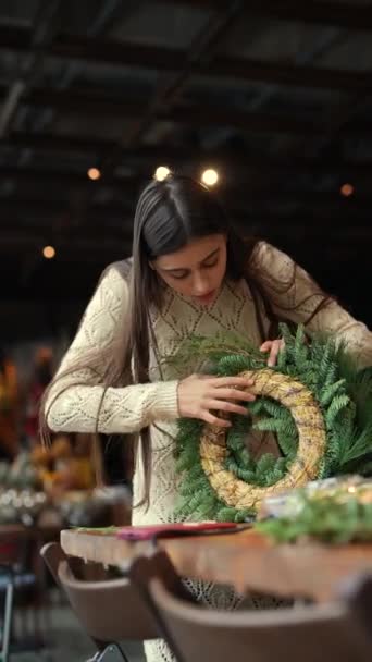 手作りのクリスマスリースを作る若い女性の創造性と優雅さを強調する写真 高品質の4K映像 — ストック動画