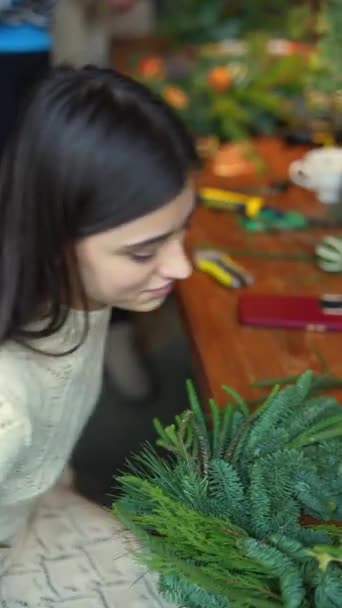 トレンディな若い女性は 火の木の枝でクリスマスリースを作成する上でマスタークラスをリードします 高品質の4K映像 — ストック動画