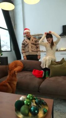 Bir çift, bir erkek ve bir kız, Noel ağacının yanında köpekleriyle oynuyorlar. Yüksek kalite 4k görüntü