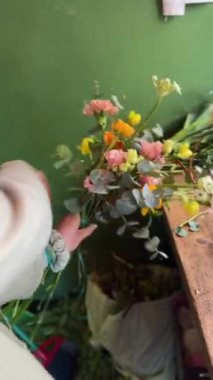 Çiçekçide, çiçekçi bir buket çiçek düzenliyor. Yüksek kalite 4k görüntü