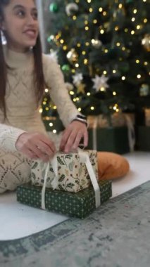 Bir kız ve tüylü arkadaşı Noel ağacının yanındaki hediyeleri açıyor. Yüksek kalite 4k görüntü