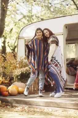 İki hippi kız, hippi kıyafetlerini karavan setine karşı sergiliyor. Yüksek kalite fotoğraf